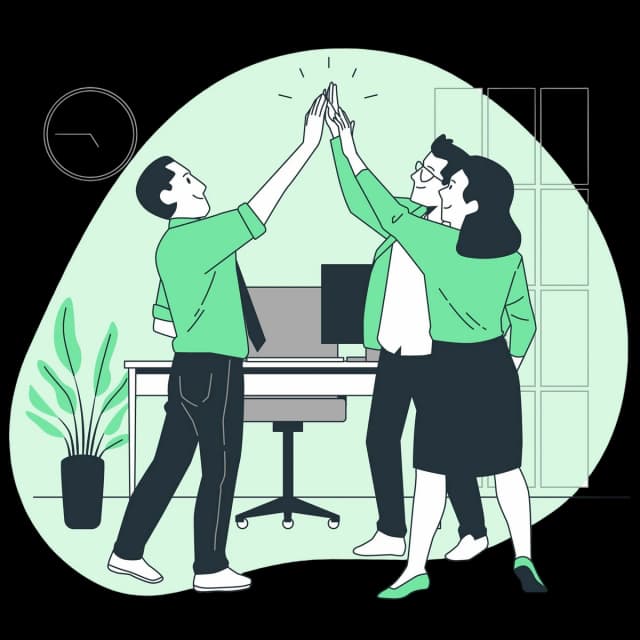 Three office colleagues giving each other a high five in front of a desk.