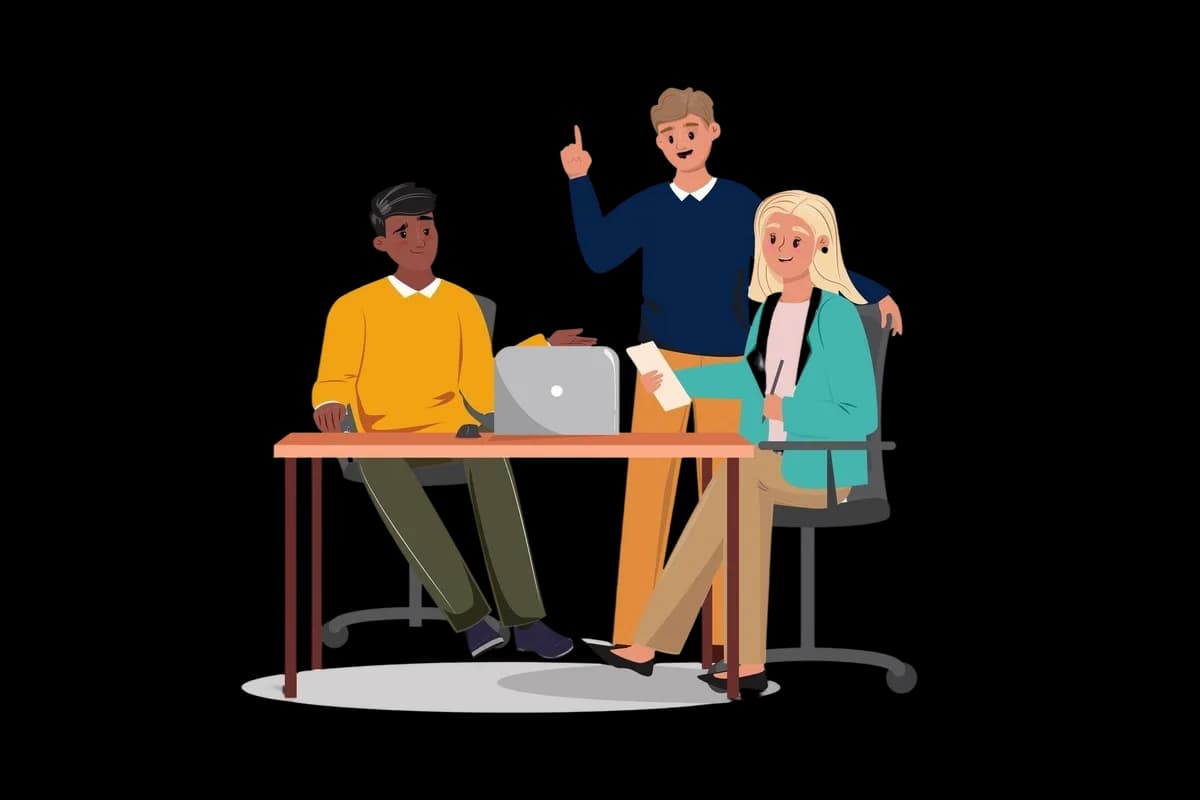 A diverse team collaborating and sharing ideas around a table with laptops.