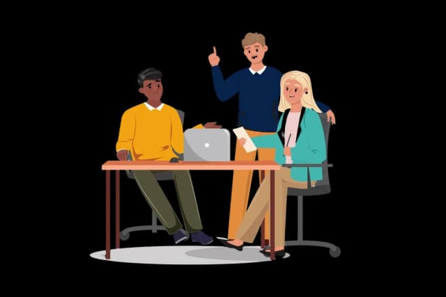 A diverse team collaborating and sharing ideas around a table with laptops.