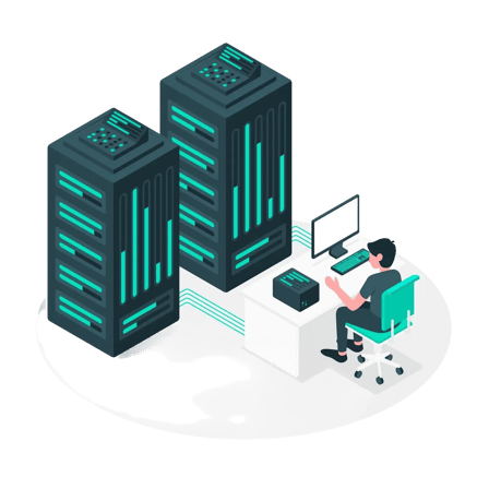 Person sitting at a desk working with large server towers in a data center environment.